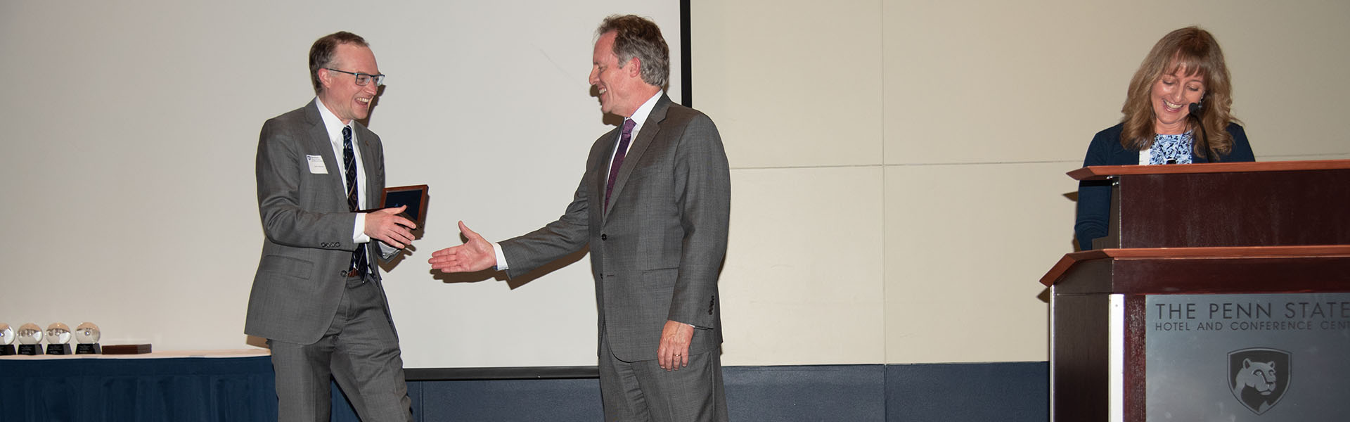 John shaking hands accepting his award