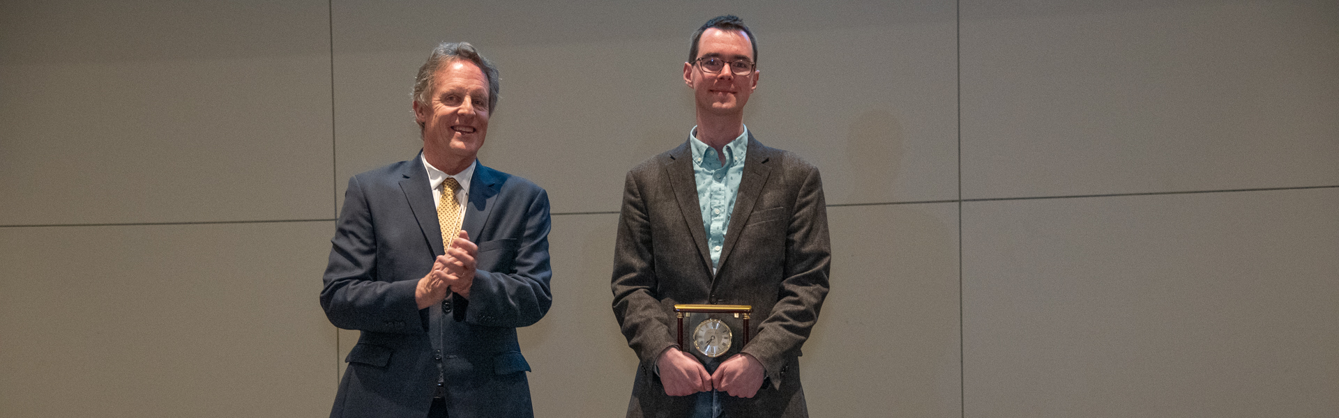 Wes holding his award on stage with Dean Kump 