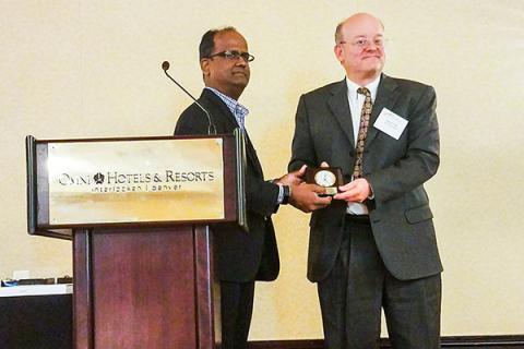 Shree Vikas, director of market intelligence and business analysis at ConocoPhillips, gives Andy Kleit the Senior Fellow Award