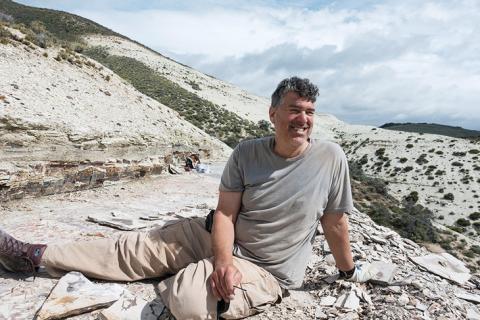 wilf sitting on a large rock and smiling