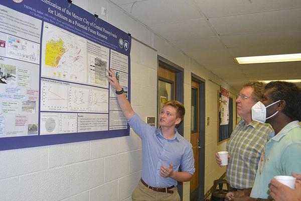 Aiden Thomas, REU participant, explains his research to Andrew Nyblade, head and professor of geosciences, and Sridhar Anandakrishnan, professor of geosciences, at the REU poster session