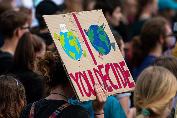 A climate activist holds a sign at a rally 