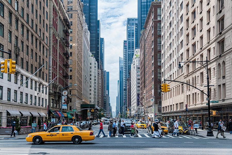 An urban canyon created by tall buildings lining a city street 