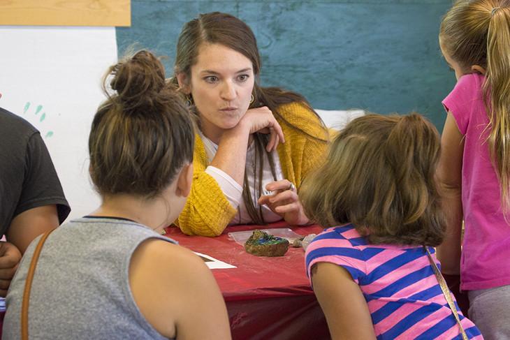 Virginia Marcon, a doctoral candidate in geosciences and co-president of the group WE ARE for Science, talks to children.